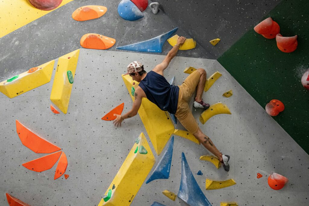 A man climbing on an indoor climbing wall during a bouldering session