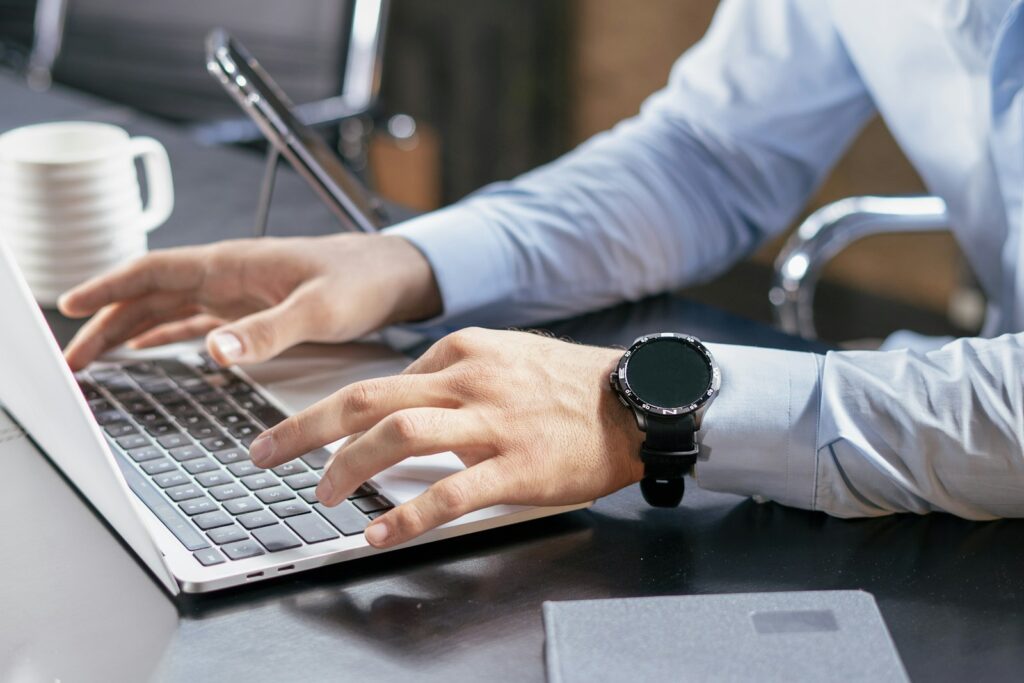 A person typing on a laptop at a desk, working through an online compliance course