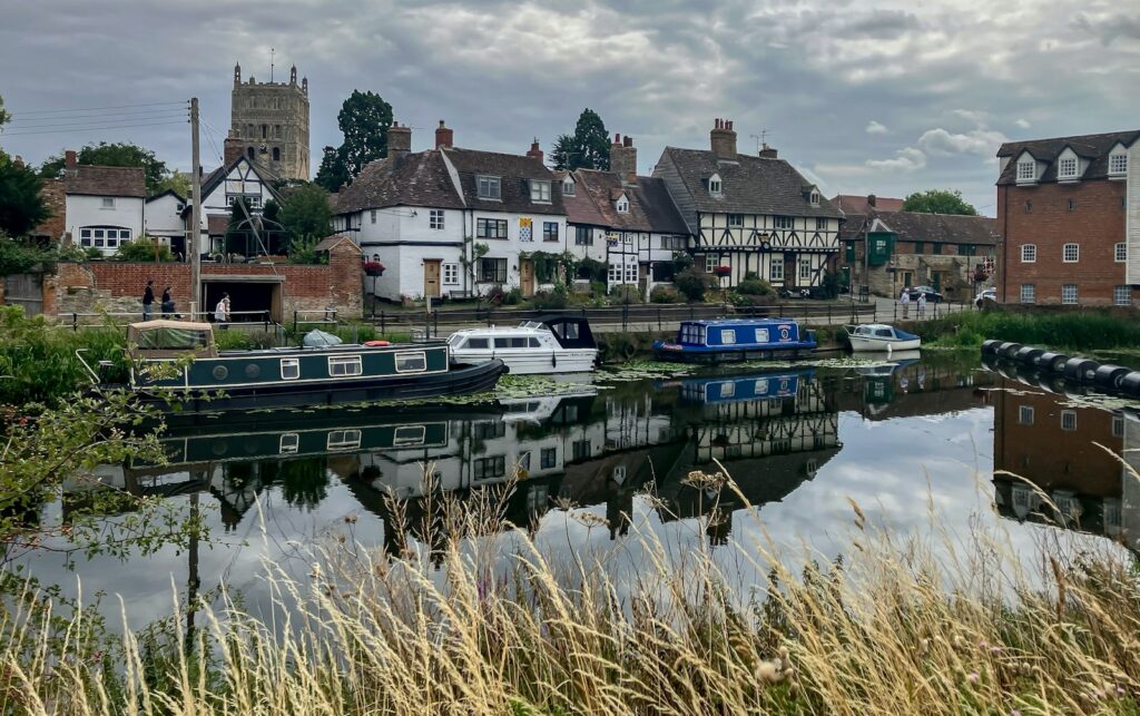 Boats and buildings reflected in the calm, rippled water of the River Avon at Tewkesbury